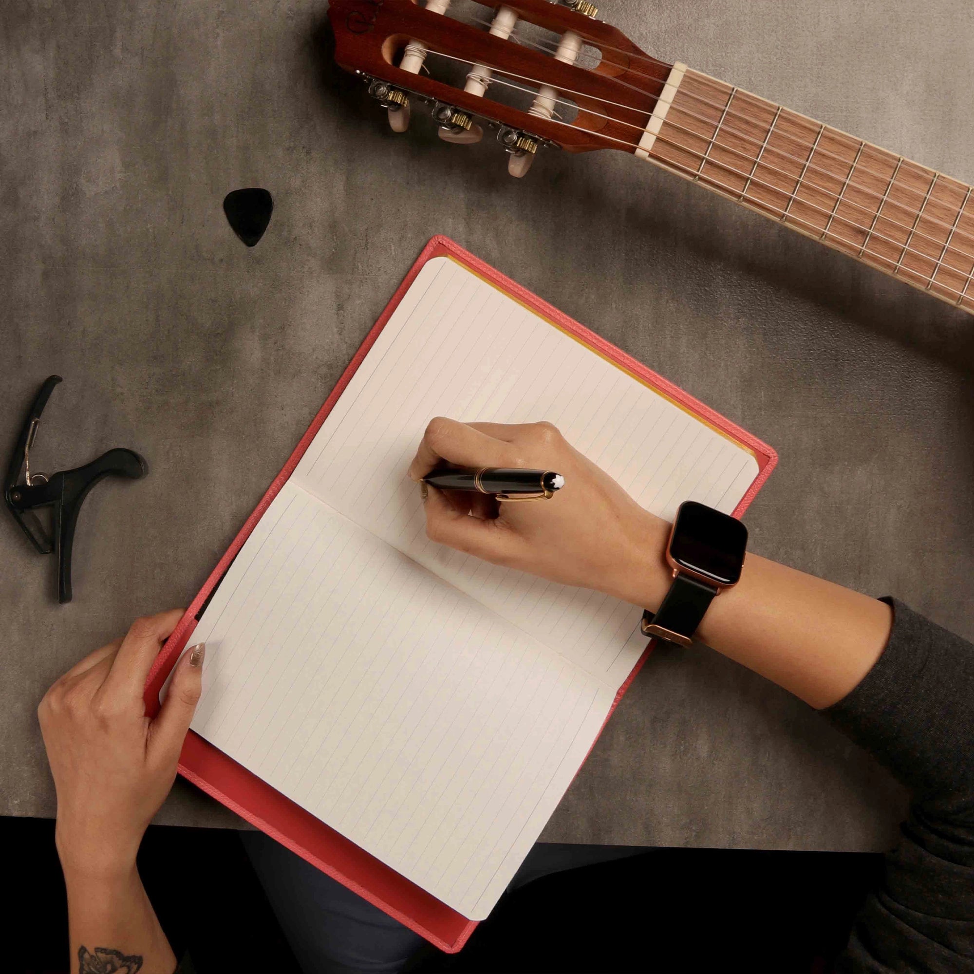 Open leather notebook on work desk with hand and accessories
